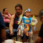 Drummer with child on knee at 2015 Ho-Chunk conference